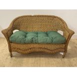 A Vintage wicker verandah two seat sofa, with squab cushion, H84cm, W150cm, D68cm