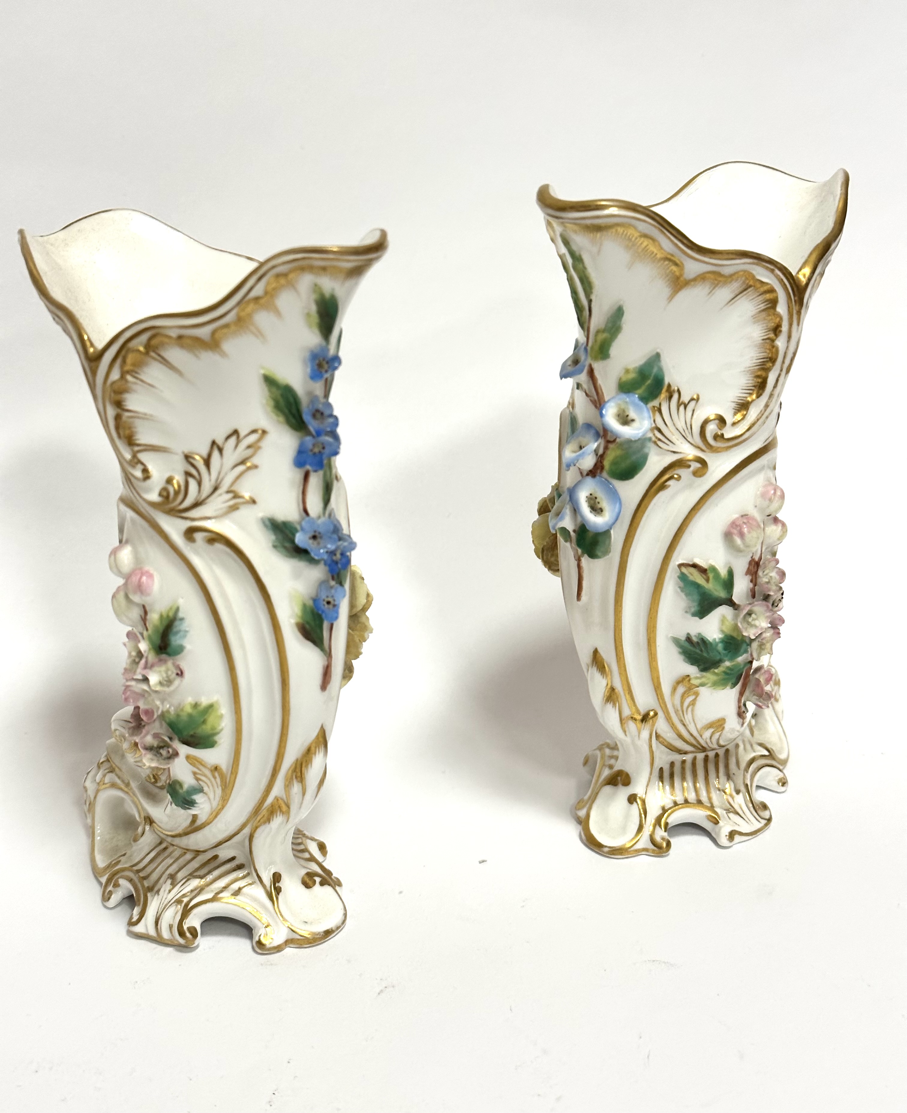 A pair of Royal Crown Derby cornucopia shaped porcelain vases decorated with floral encrusted sprays