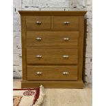 A modern light oak chest, fitted with two short and three long graduated drawers, raised on a
