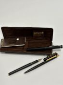 A Mont Blanc set of two black enamelled pens including a fountain pen and ball point pen, complete