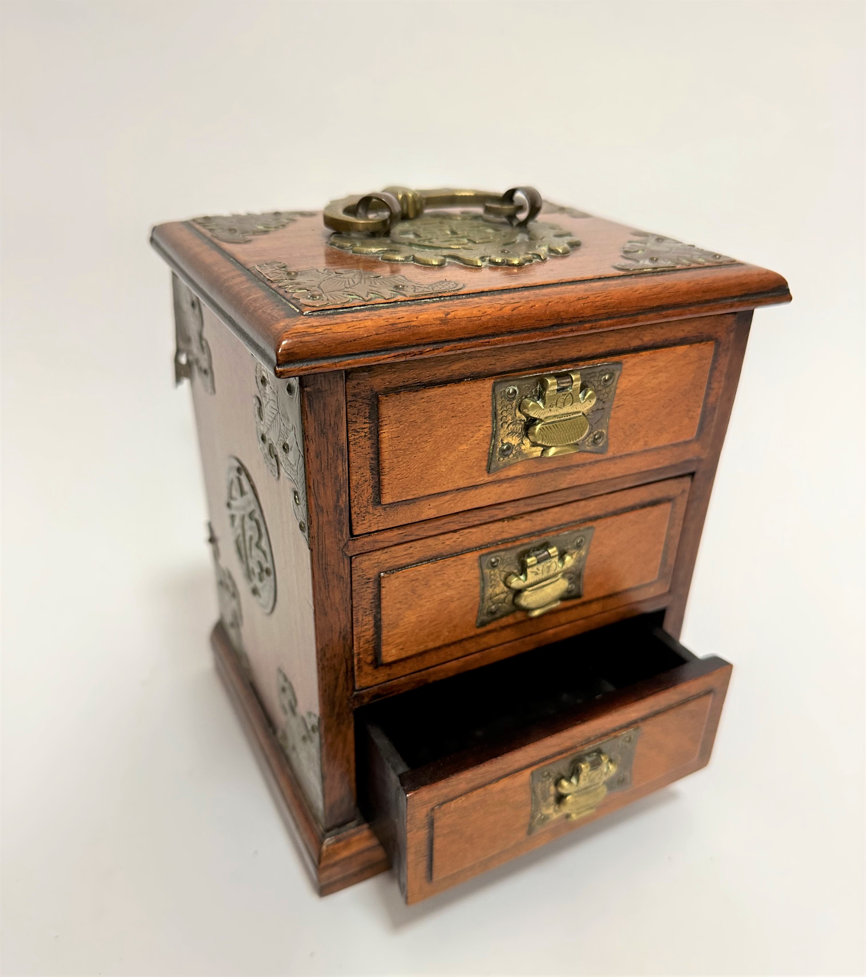 A Chinese 1920's cherrywood miniature casket with brass hinged handle to top, with bat engraved