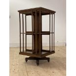 An Edwardian oak two tier revolving bookcase, with moulded slats, raised on cruciform base