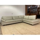 A Contemporary cream leather upholstered corner sofa, raised on brushed metal square section