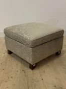 A modern floral upholstered ottoman footstool, with lift up top enclosing a storage well, raised