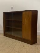 A mid century teak bookcase, twin sliding glass doors enclosing two adjustable shelves, flanked by a