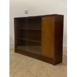 A mid century teak bookcase, twin sliding glass doors enclosing two adjustable shelves, flanked by a