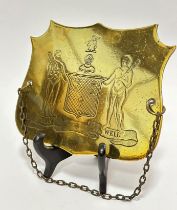 A Georgian brass shield shaped plaque with two male bearded native figures holding clubs and