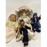 A bendy clown modern figure, a modern bisque head doll with mop cap and striped dress with pinafore,