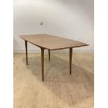 McIntosh, A mid century teak extending dining table, the shaped and moulded top with folding leaf