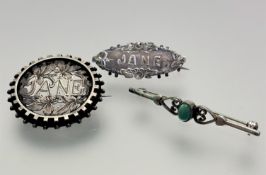An Edwardian white metal circular open work engraved brooch. "Jane", (d: 3.5cm) and an Edwardian