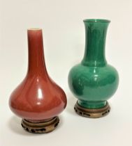A Chinese late 19thc Sang de Beuf glazed slim necked baluster vase on hardwood stand, (h 22cm x d