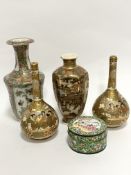 A pair of Japanese bottle neck Satsuma vases decorated with figures enclosed within gilt reserves,