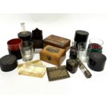 Five various medical glasses and containers complete with original textured cloth holders, a