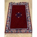 A Chinese washed wool rug, the red field with floral medallion and ivory border, 200cm x 310cm