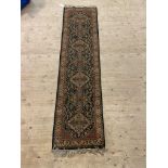 A Persian design Shiraz runner rug, the green field with repeating lozenges and bordered, 236cm x