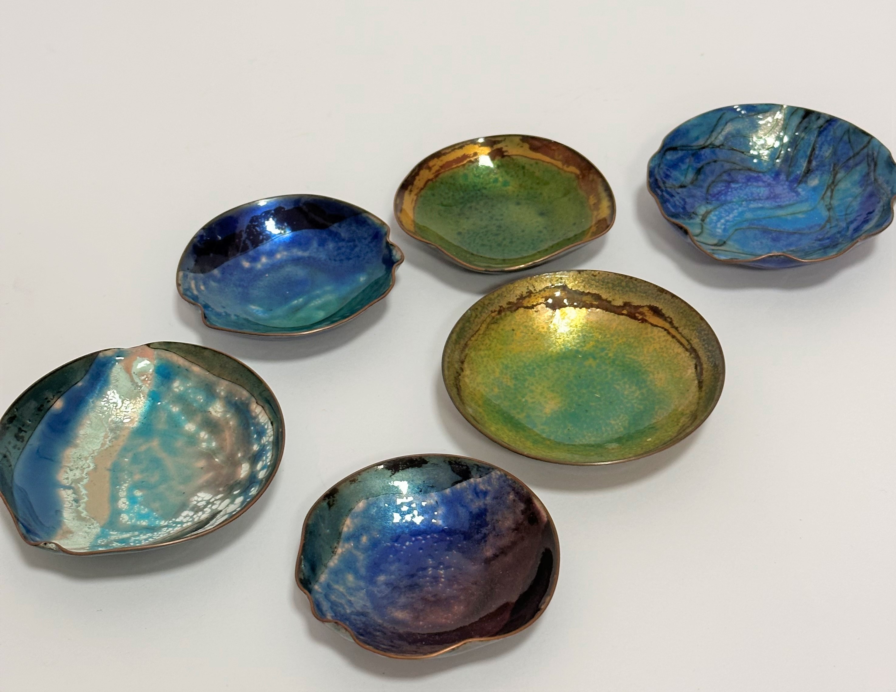 A group of six various miniature copper enamelled butter dishes of various stylised forms