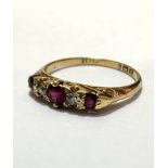 An 18ct gold three stone ruby and and two stone diamond ring, 0.2ct, flanked by a mixed cut stone