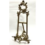 An Edwardian style cast brass picture easel of C scroll and S scroll design and tripod stand, (56cm,