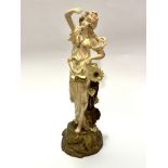 An Austrian Tum Wien figure with arm raised up with sunflower to side, raised on naturalistic