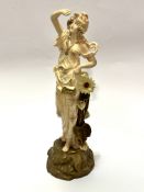 An Austrian Tum Wien figure with arm raised up with sunflower to side, raised on naturalistic