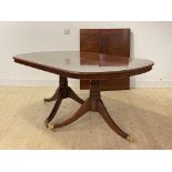 A Regency style inlaid mahogany twin pillar dining table, the top with two 'D' ends and two leaves