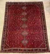 A Caucasian hand knotted carpet, the red field with pole medallion and intricately decorated with