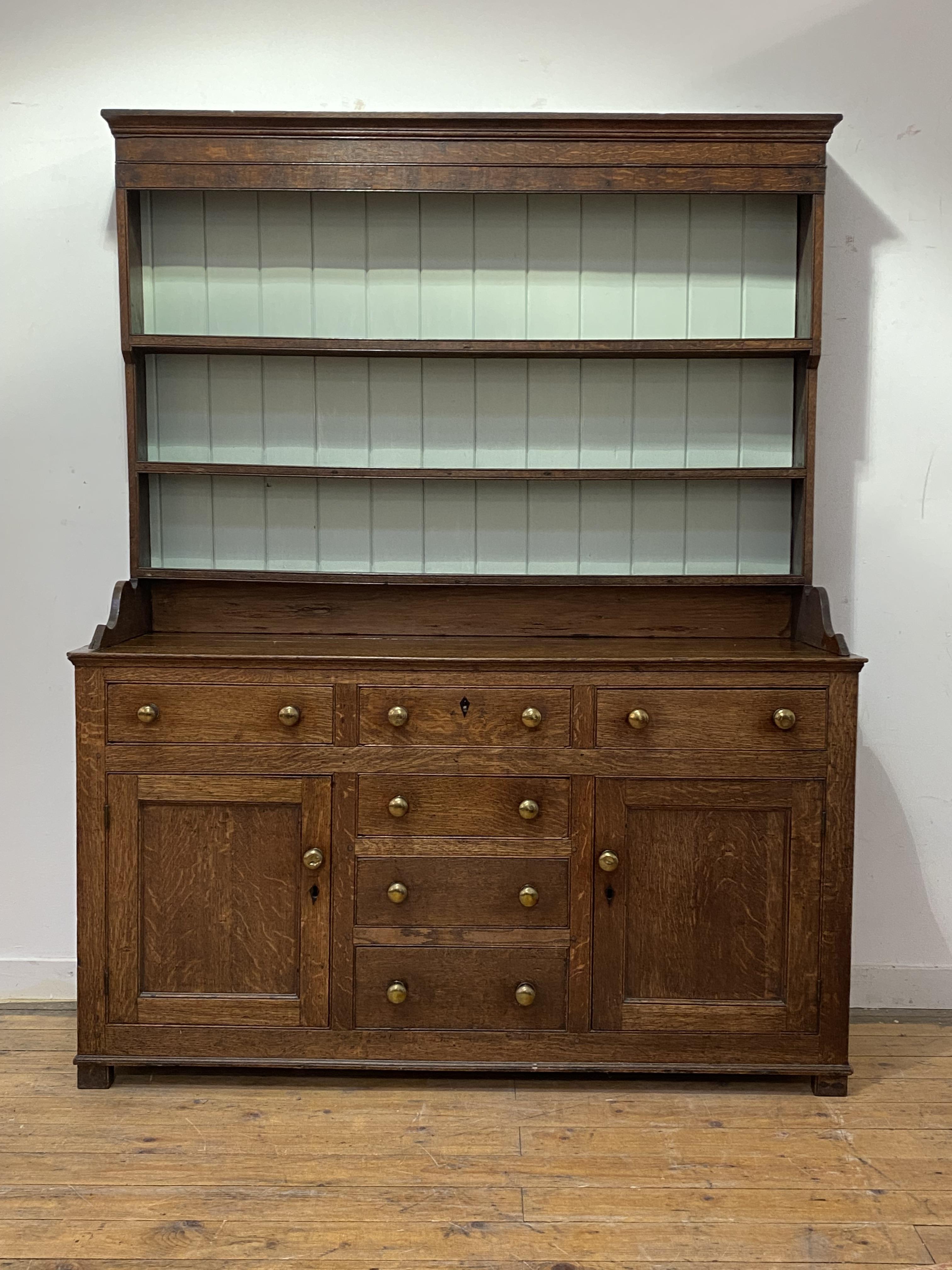 A small 18th century country oak dresser, the three height plate rack with projecting cornice and