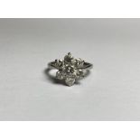 A seven stone diamond cluster ring, of flowerhead form, the central round brilliant-cut stone