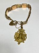 A 9ct gold gatelink bracelet suspending a 15ct gold shield-form fob, the bracelet spaced by engraved