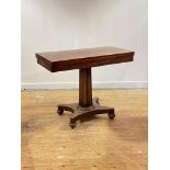 A mid 19th century mahogany supper table, the fold over revolving top over a fluted centre column,