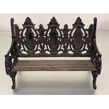 A miniature cast iron bench after a Coalbrookdale design, with slatted wooden seat. 27.5cm by 41cm