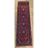 A Persian Kashan Runner rug, hand knotted, the red field with with four lozenge medallions and