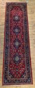 A Persian Kashan Runner rug, hand knotted, the red field with with four lozenge medallions and