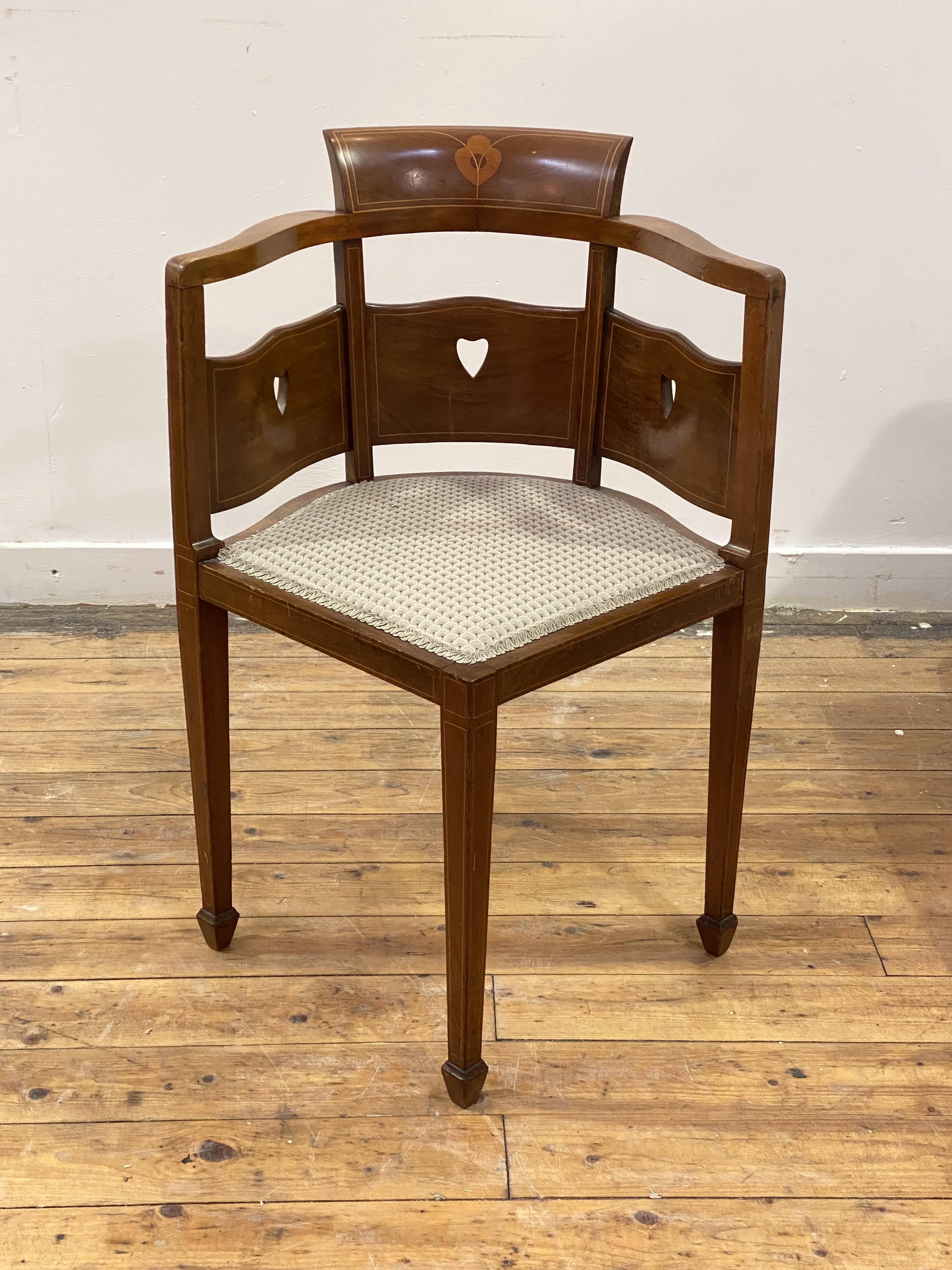 An Arts and Crafts period mahogany corner chair, the crest rail and pierced back over upholstered