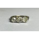 A three-stone diamond ring, the graduated round brilliant-cut stones claw-set on a platinum band.