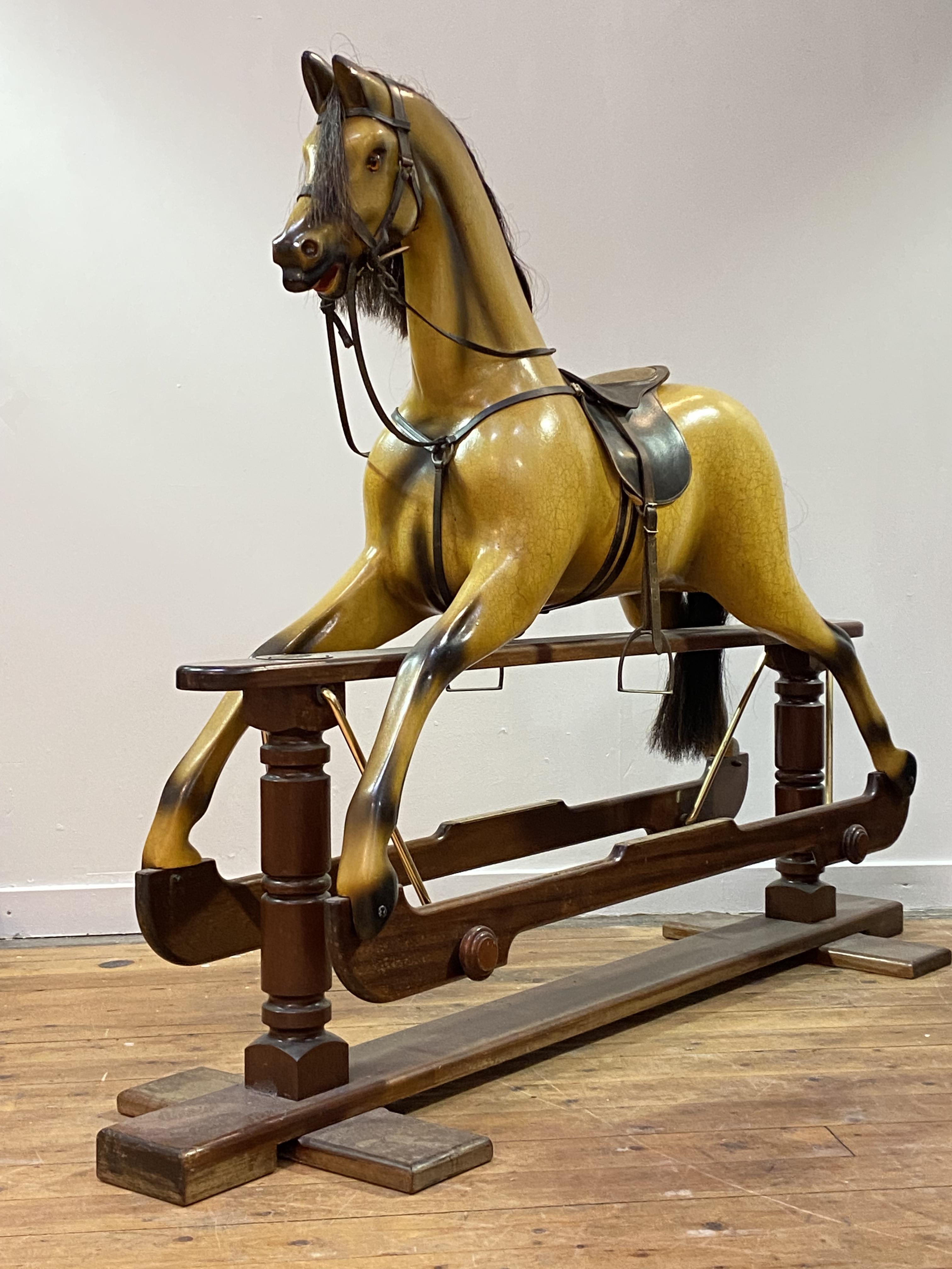 A Whittingham Crafts Ltd. carved and painted wooden trestle rocking horse, painted mustard, with