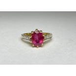 A single stone ruby ring with diamond-set shoulders, the oval-cut ruby claw-set above shoulders each