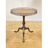 A George III mahogany tilt top tripod table, the circular top with turned spindle gallery over