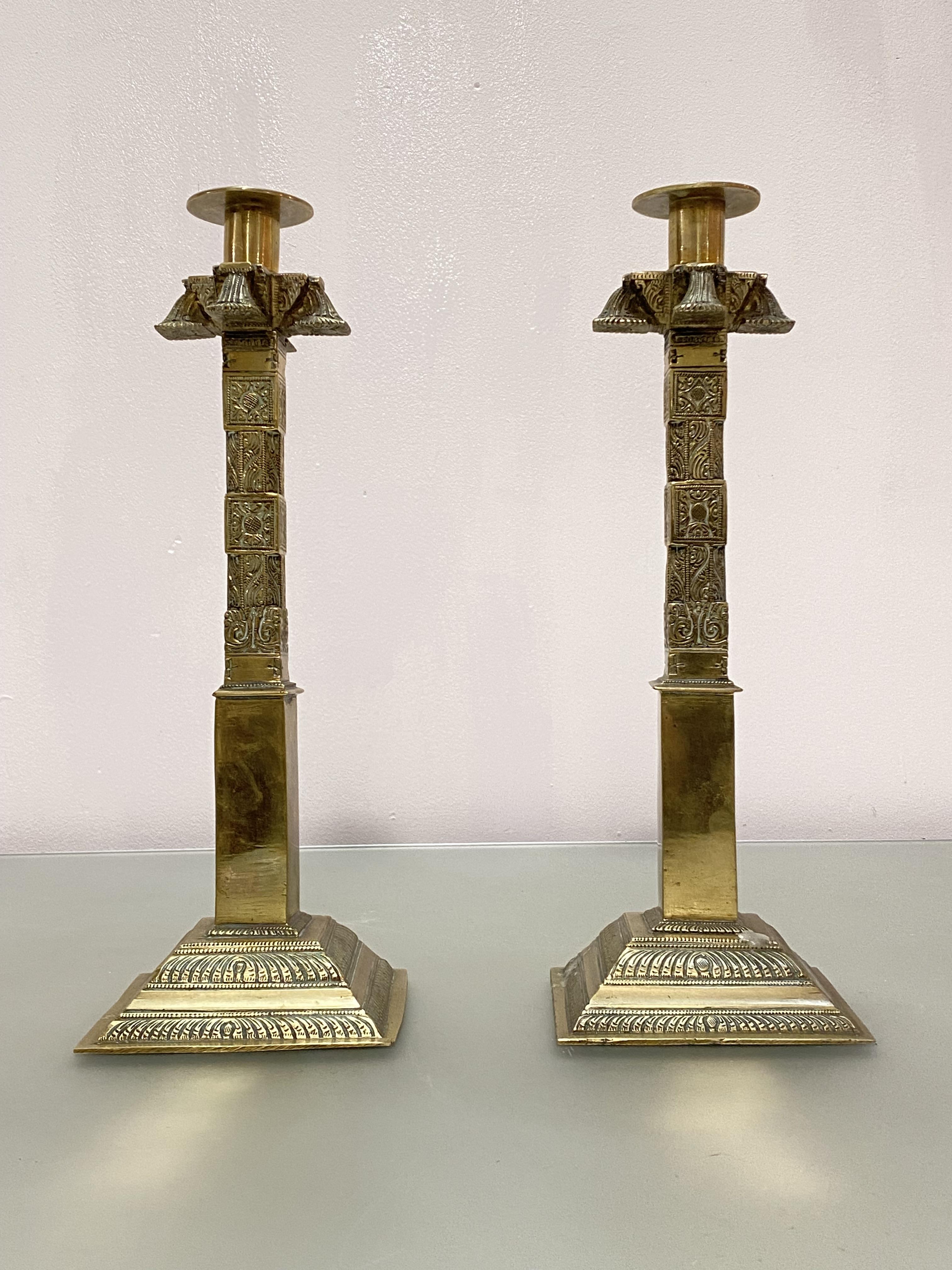 A pair of tall polished bronze candlestics, possibly Chinese, of square section, the stepped base