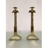 A pair of tall polished bronze candlestics, possibly Chinese, of square section, the stepped base