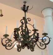 A patinated wrought iron chandelier in Baroque style, early 20th century, the hammered copper boss