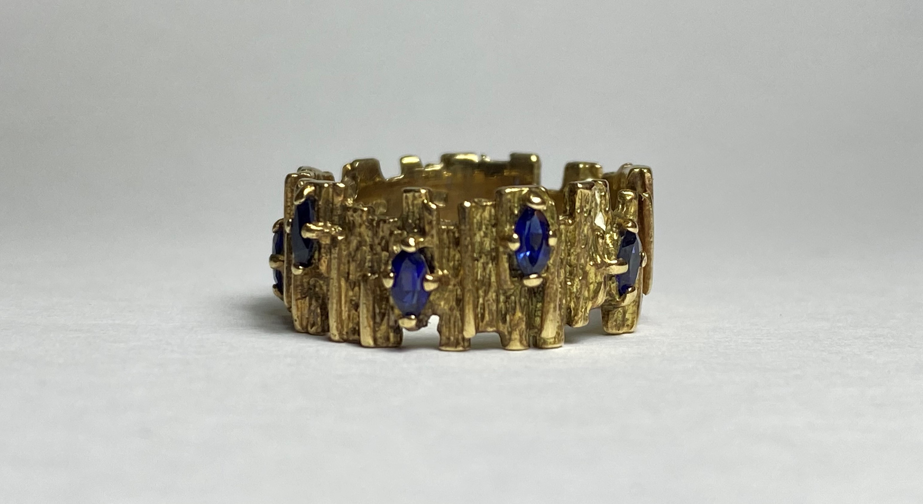 A vintage sapphire-set 9ct gold ring, the textured bark band claw-set with marquise-cut sapphires.