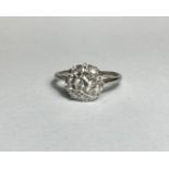 A diamond and moissanite cluster ring, the central round brilliant-cut diamond claw-set within a