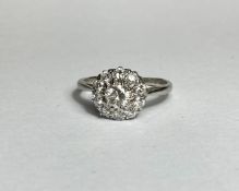 A diamond and moissanite cluster ring, the central round brilliant-cut diamond claw-set within a