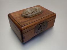 A Chinese carved openwork jade plaque inset into a hardwood box, the pale celadon domed oval