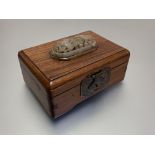 A Chinese carved openwork jade plaque inset into a hardwood box, the pale celadon domed oval