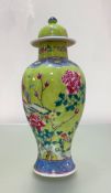 A Chinese famille rose porcelain vase and cover, of baluster form, painted with a bird perched