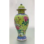 A Chinese famille rose porcelain vase and cover, of baluster form, painted with a bird perched