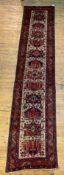 A Persian runner rug, hand knotted, the ivory field with pole medallion, birds, butterflies and