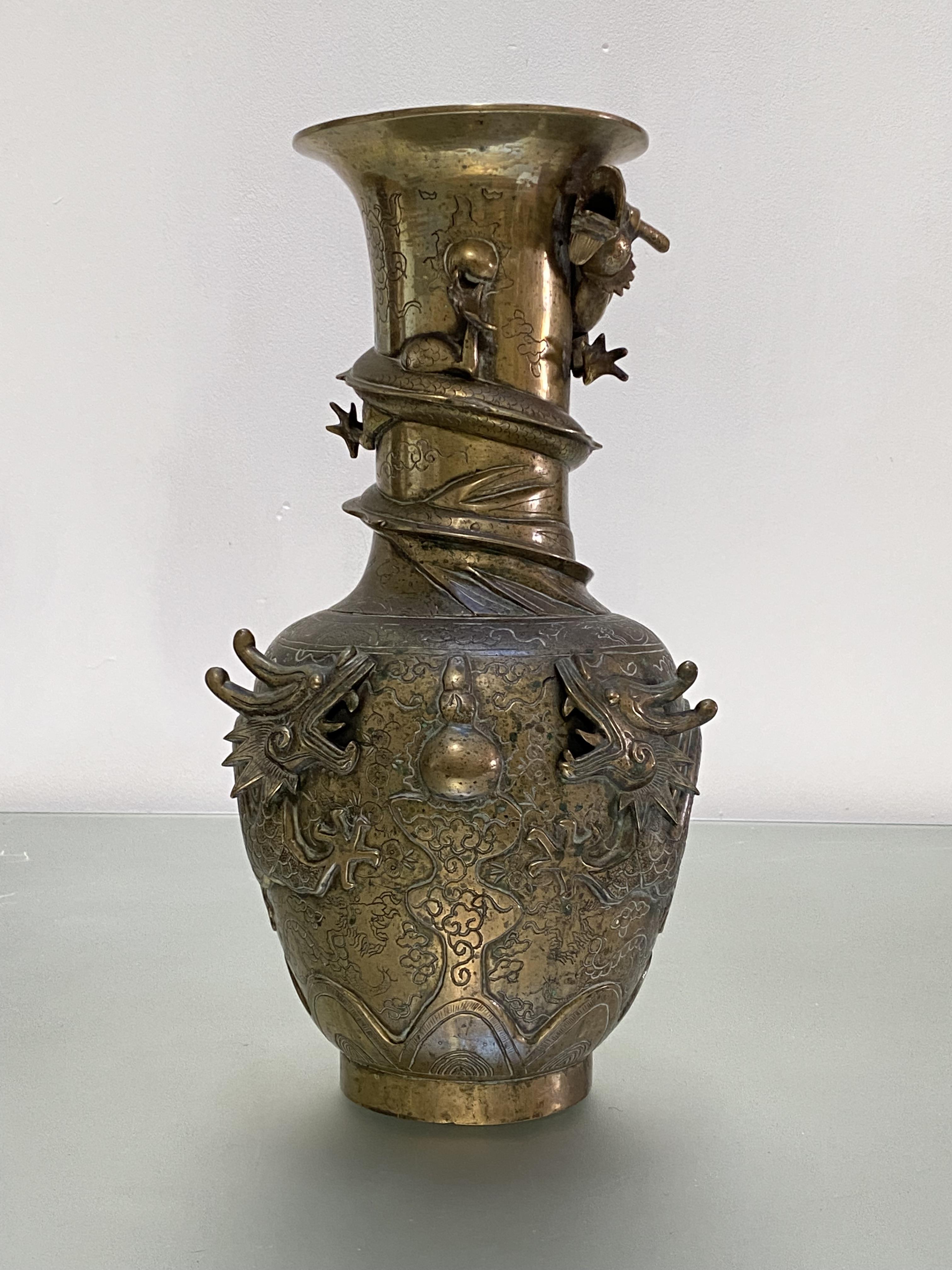 A large Chinese bronze baluster vase, c. 1900, cast in high relief with dragons and a flaming pearl,